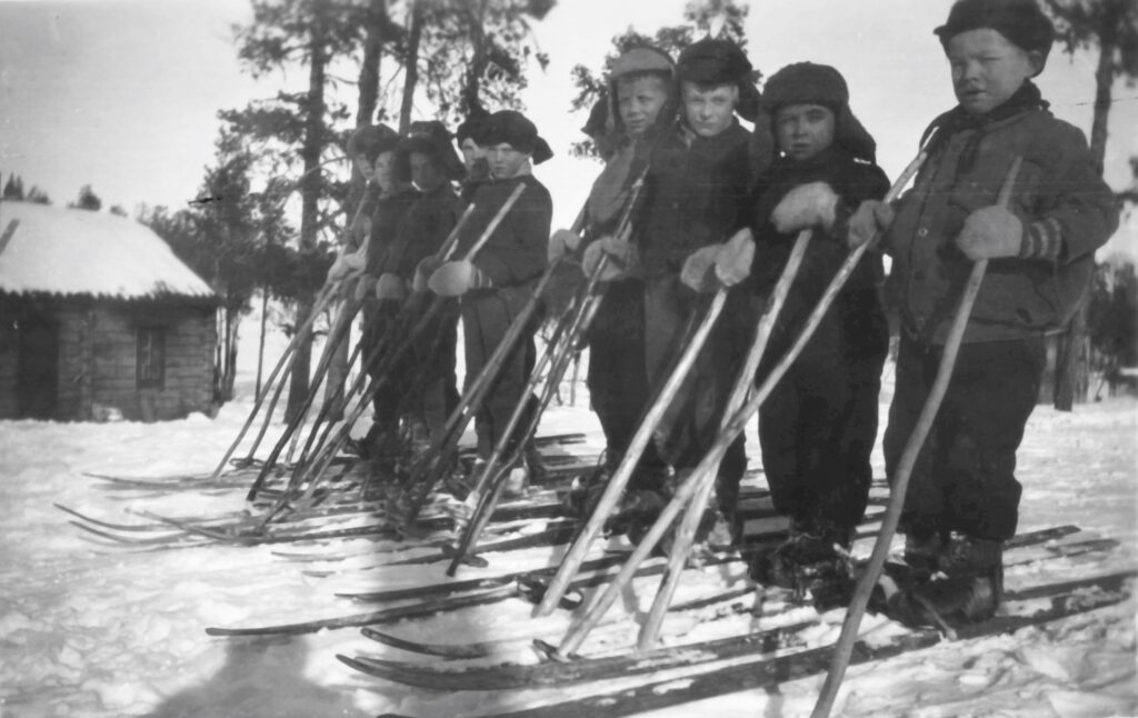 Kuvassa Suonikylän koulun oppilaita aloittamassa hiihtokilpailua vuonna 1935. Anni Tattari, Museoviraston suomalais-ugrilainen kuvakokoelma, CC BY 4.0.